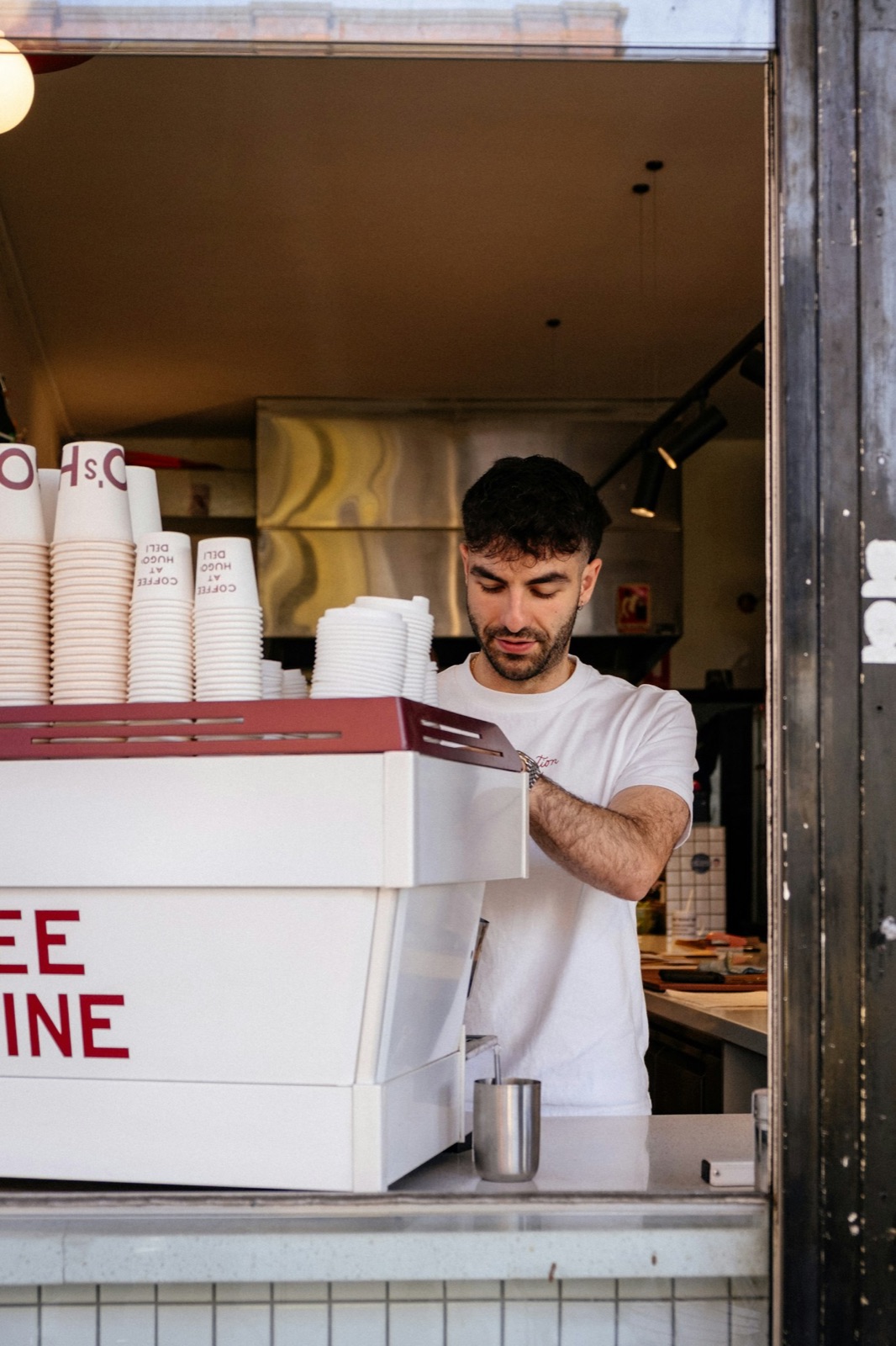 Barista preparando café atrás do balcão de uma cafeteria